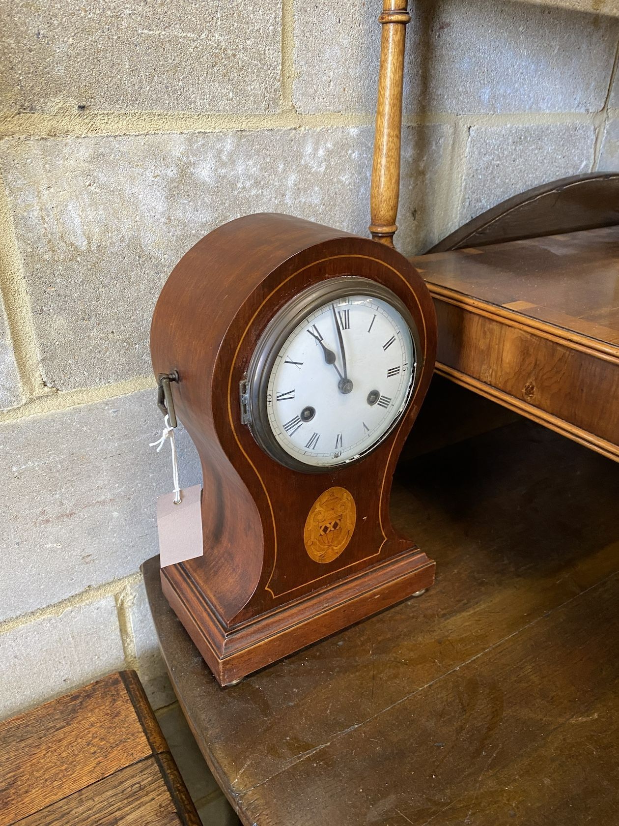 An Edwardian inlaid mahogany tear drop mantel clock, height 34cm and a carved oak aneroid wheel barometer, height 86cm